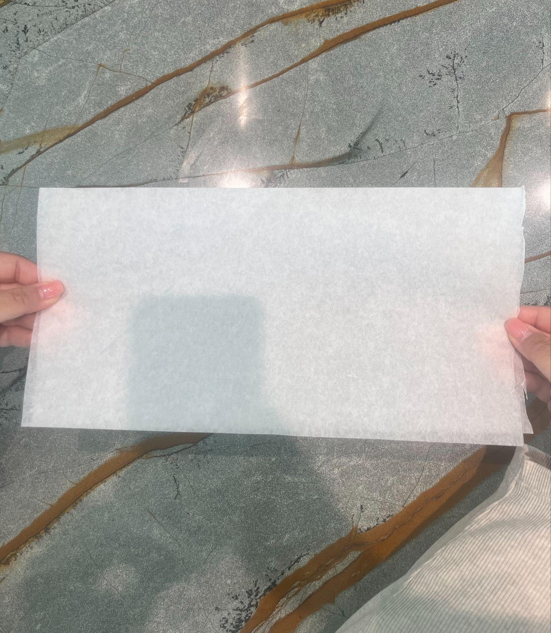 Hands holding parchment paper folded in half into a rectangle