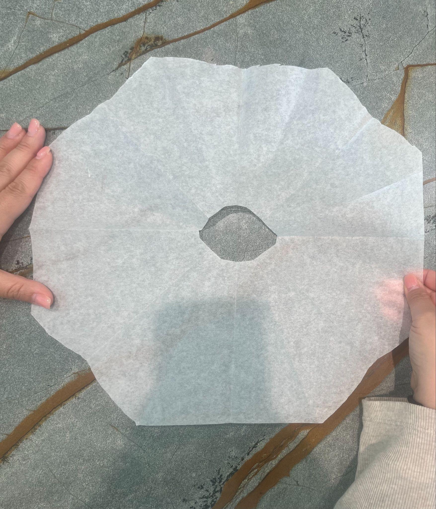 Unfolded parchment cartouche with a center hole and curved edge